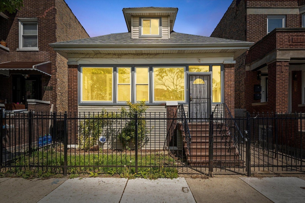 view of front of home featuring a fenced front yard and roof with shingles