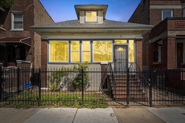 view of front of home featuring a fenced front yard and roof with shingles