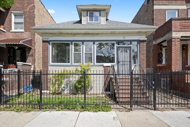 view of front of house featuring a fenced front yard and a shingled roof