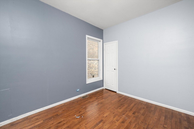 empty room featuring baseboards and wood finished floors