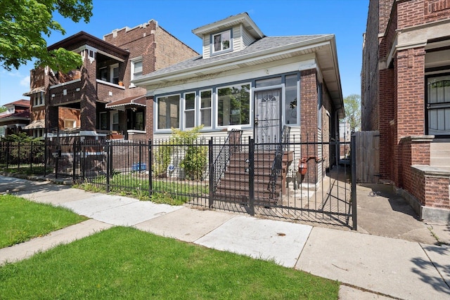 view of front facade featuring a fenced front yard, brick siding, a gate, and roof with shingles