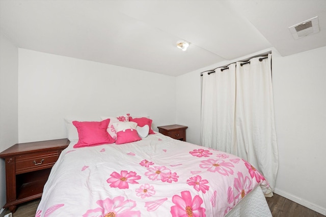 bedroom with wood finished floors and baseboards