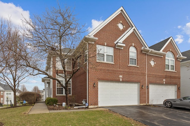 119 Allerton Dr, Schaumburg, IL 60194 - view of front of house with an attached garage, brick siding, driveway, and a front lawn