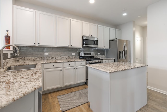 119 Allerton Dr, Schaumburg, IL 60194 - kitchen with appliances with stainless steel finishes, a sink, light wood-style floors, backsplash, and a kitchen island