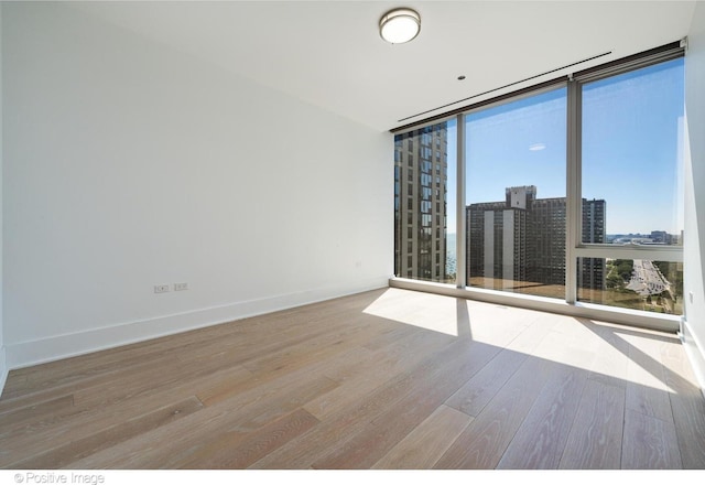363 E Wacker Dr Unit 1903, Chicago, IL 60601 - empty room with floor to ceiling windows, wood finished floors, baseboards, and a view of city