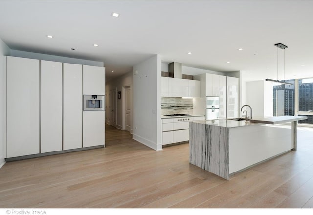 363 E Wacker Dr Unit 1903, Chicago, IL 60601 - kitchen featuring modern cabinets, light wood-type flooring, a sink, white cabinets, and tasteful backsplash