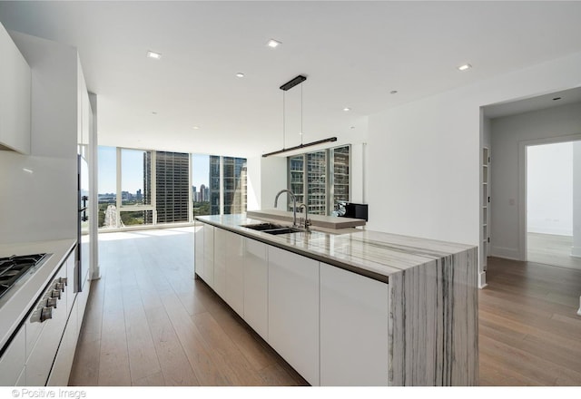 363 E Wacker Dr Unit 1903, Chicago, IL 60601 - kitchen featuring a sink, white cabinetry, light wood-style floors, modern cabinets, and light stone countertops