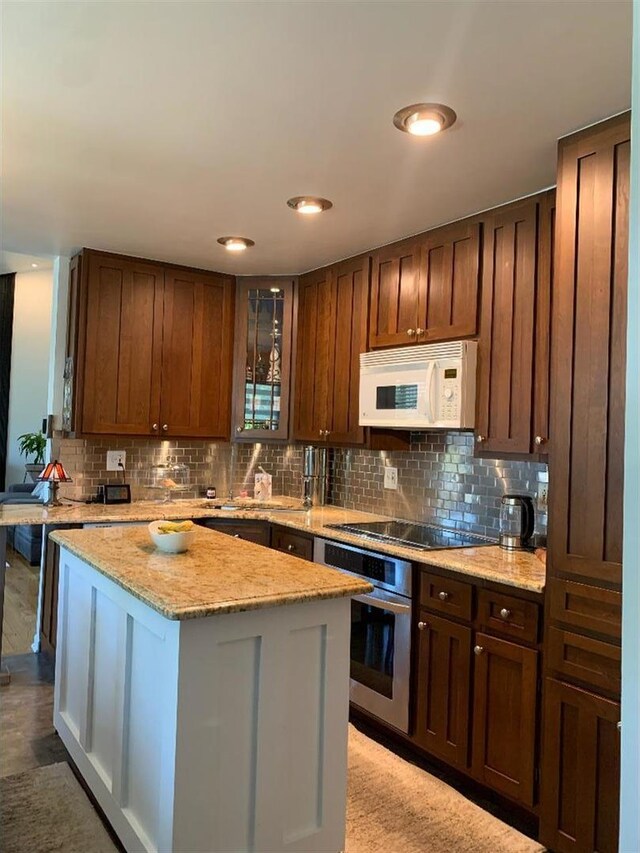 8632 New England Ave, Burbank, IL 60459 - kitchen featuring white microwave, black electric stovetop, stainless steel oven, backsplash, and recessed lighting