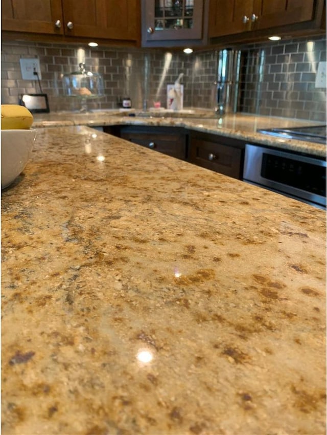8632 New England Ave, Burbank, IL 60459 - kitchen with oven, backsplash, glass insert cabinets, and light stone countertops