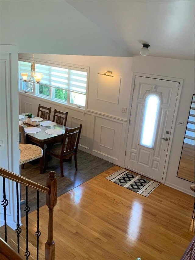 8632 New England Ave, Burbank, IL 60459 - entrance foyer with wood finished floors, a chandelier, wainscoting, vaulted ceiling, and a decorative wall