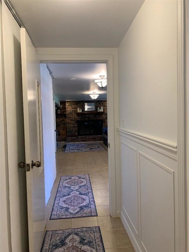 8632 New England Ave, Burbank, IL 60459 - hallway featuring light tile patterned flooring, wainscoting, brick wall, and a decorative wall