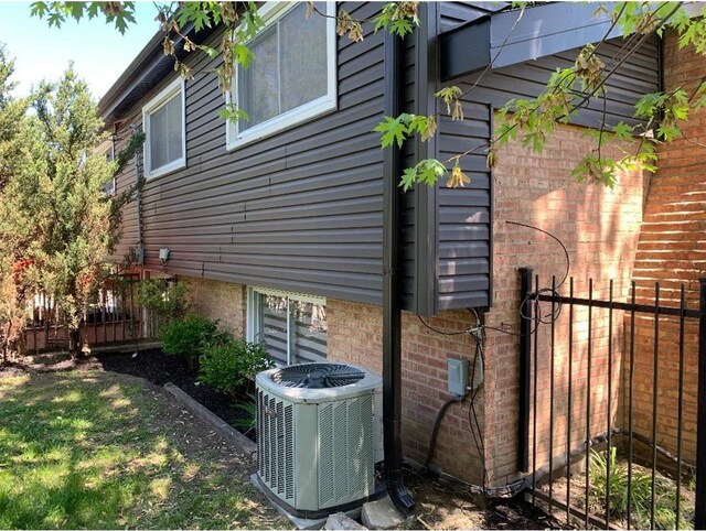 8632 New England Ave, Burbank, IL 60459 - view of side of home with central air condition unit, fence, and brick siding