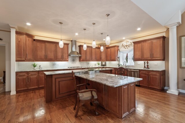 5419 Rita Ave, Crystal Lake, IL 60014 - kitchen featuring wall chimney exhaust hood, a kitchen island, decorative columns, decorative backsplash, and brown cabinetry