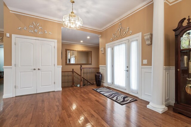 5419 Rita Ave, Crystal Lake, IL 60014 - entrance foyer featuring decorative columns, crown molding, wood finished floors, a chandelier, and wainscoting