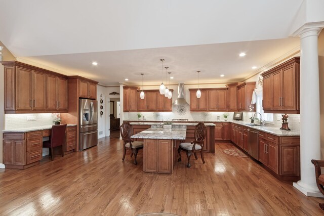 5419 Rita Ave, Crystal Lake, IL 60014 - kitchen featuring appliances with stainless steel finishes, wall chimney exhaust hood, a breakfast bar, a kitchen island, and wood finished floors