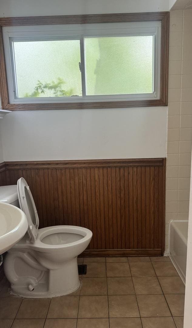331 Somonauk St, Park Forest, IL 60466 - full bathroom featuring plenty of natural light, toilet, a bath, tile patterned floors, and a wainscoted wall