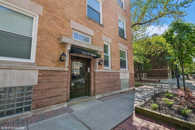 view of exterior entry with brick siding