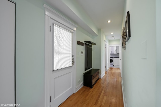 hallway with recessed lighting, light wood finished floors, washer / dryer, and baseboards