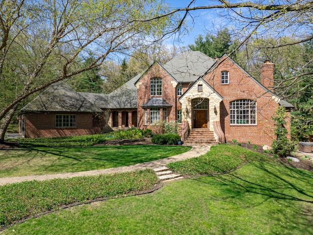 9430 Reserve Dr, Caledonia, IL 61011 - view of front of house with a chimney, a front lawn, brick siding, and stone siding