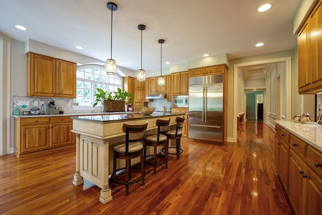 9430 Reserve Dr, Caledonia, IL 61011 - kitchen featuring built in appliances, dark wood-type flooring, brown cabinets, tasteful backsplash, and recessed lighting