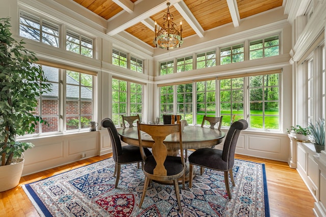9430 Reserve Dr, Caledonia, IL 61011 - dining area featuring wooden ceiling, a decorative wall, a chandelier, beamed ceiling, and light wood-style flooring