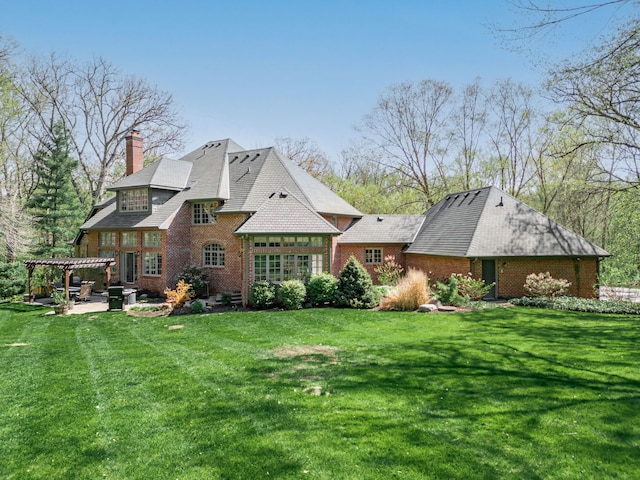 9430 Reserve Dr, Caledonia, IL 61011 - rear view of property featuring a pergola, brick siding, a patio area, and a yard