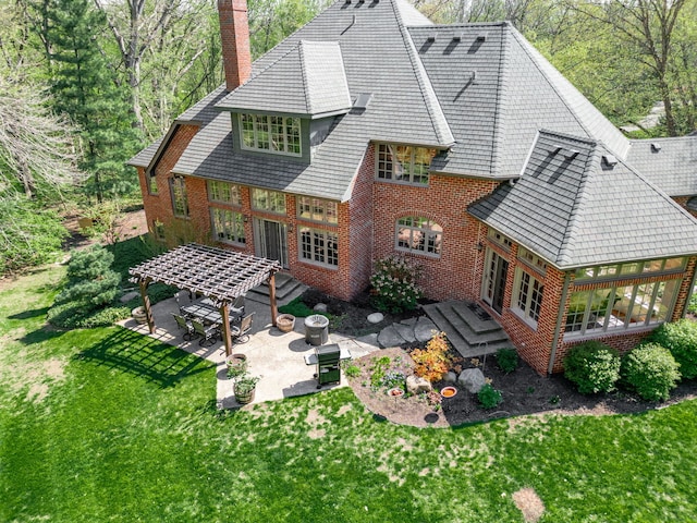 9430 Reserve Dr, Caledonia, IL 61011 - back of house with a patio, a chimney, brick siding, a lawn, and a deck
