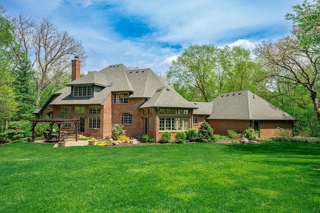 9430 Reserve Dr, Caledonia, IL 61011 - rear view of house featuring brick siding, a pergola, a patio, and a yard