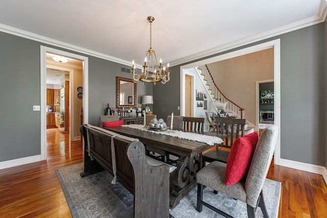 9430 Reserve Dr, Caledonia, IL 61011 - dining space featuring a chandelier, stairs, baseboards, wood finished floors, and crown molding