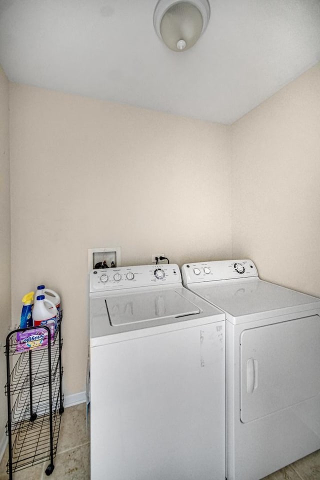 7658 S Greenwood Ave, Chicago, IL 60619 - washroom featuring separate washer and dryer, baseboards, and light tile patterned floors