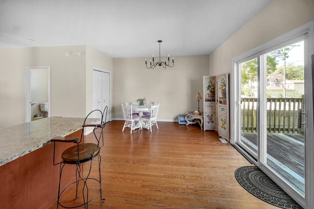 7658 S Greenwood Ave, Chicago, IL 60619 - dining room featuring a chandelier, light wood-style flooring, and baseboards