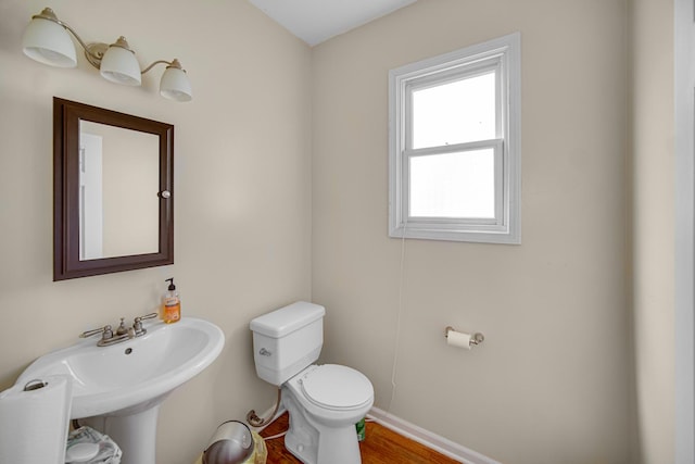 7658 S Greenwood Ave, Chicago, IL 60619 - half bathroom featuring toilet, baseboards, a sink, and wood finished floors