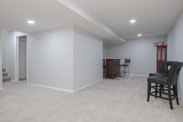 finished below grade area with a dry bar, carpet, recessed lighting, baseboards, and stairway