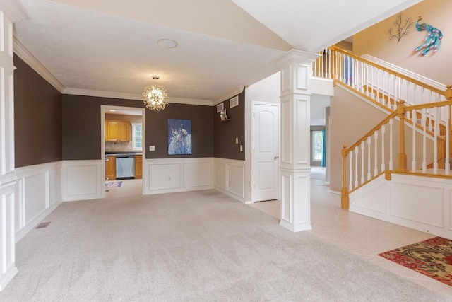 unfurnished dining area featuring a decorative wall, light carpet, ornate columns, stairs, and wainscoting