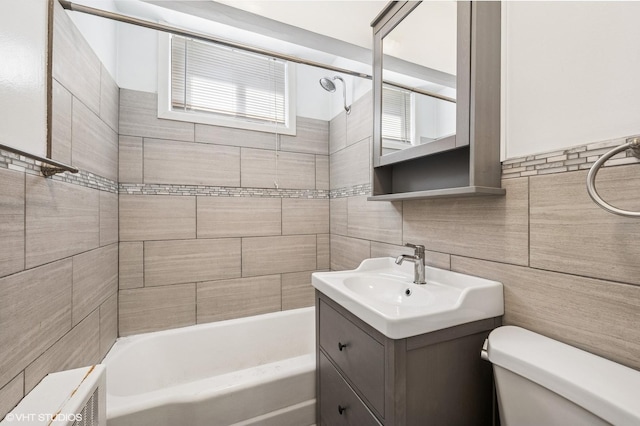full bathroom with toilet, vanity, tile walls, and bathtub / shower combination