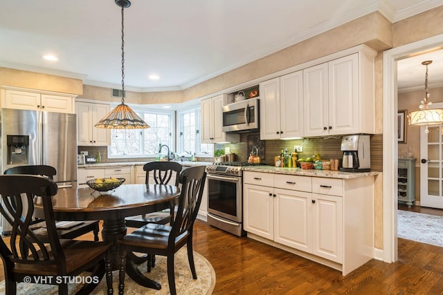 401 S Carlyle Pl, Arlington Heights, IL 60004 - kitchen with appliances with stainless steel finishes, dark wood-style flooring, hanging light fixtures, backsplash, and ornamental molding