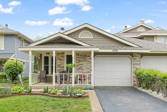 1592 Lighthouse Dr, Naperville, IL 60565 - view of front of property featuring a porch, driveway, a shingled roof, an attached garage, and a front yard