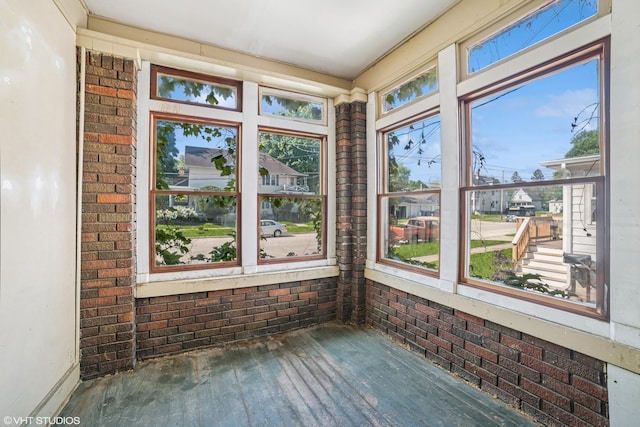 827 Lewis St, Dekalb, IL 60115 - unfurnished sunroom with wood-type flooring and brick wall