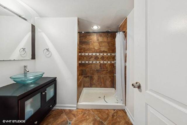 full bathroom featuring a shower stall, vanity, baseboards, and recessed lighting