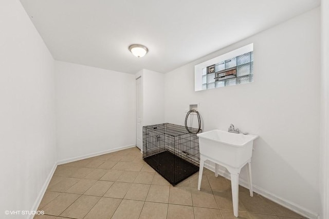 bedroom featuring light tile patterned flooring and baseboards