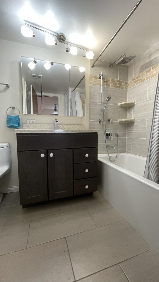 6221 N Niagara Ave Unit 401, Chicago, IL 60631 - full bath featuring tile patterned floors, toilet, shower / tub combo with curtain, and vanity