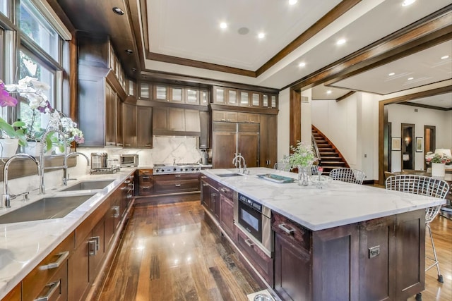 6535 N Tower Circle Dr, Lincolnwood, IL 60712 - kitchen featuring dark wood-type flooring, a sink, tasteful backsplash, ornamental molding, and light stone counters