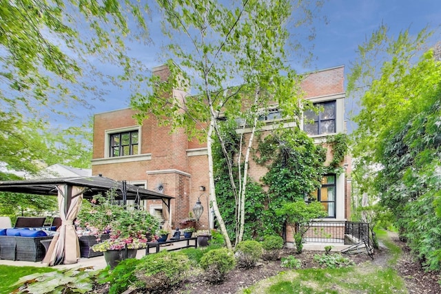 6535 N Tower Circle Dr, Lincolnwood, IL 60712 - back of property featuring a gazebo, an outdoor living space, a patio area, and brick siding