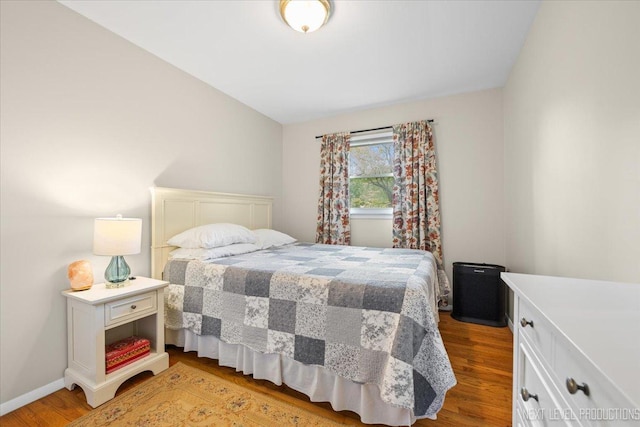 bedroom featuring light wood finished floors and baseboards