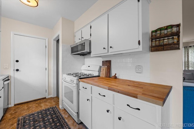 kitchen featuring appliances with stainless steel finishes, wooden counters, white cabinetry, and decorative backsplash