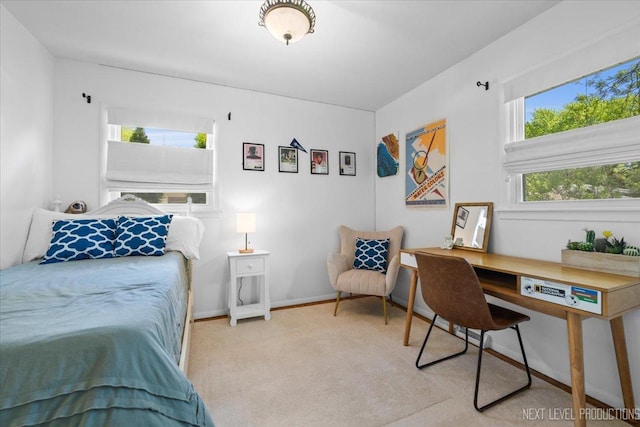 bedroom featuring an office area, carpet floors, and baseboards