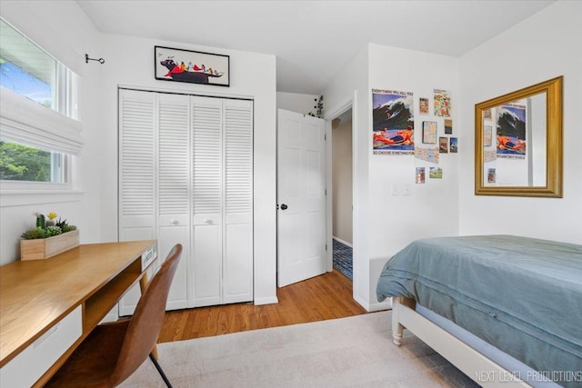 bedroom featuring wood finished floors, a closet, and a desk