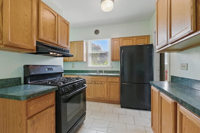 kitchen featuring black appliances, a sink, dark countertops, under cabinet range hood, and light tile patterned floors