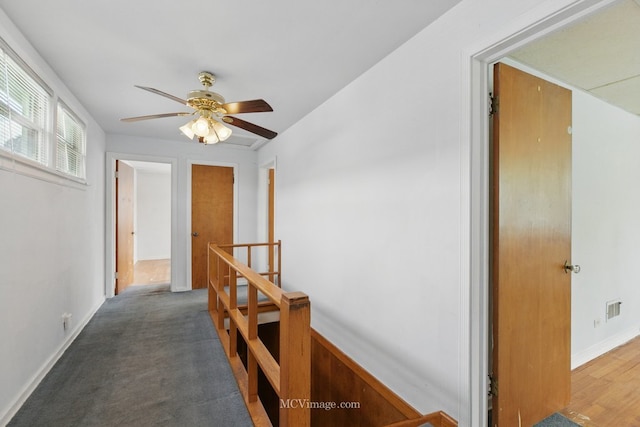 hall featuring an upstairs landing and baseboards