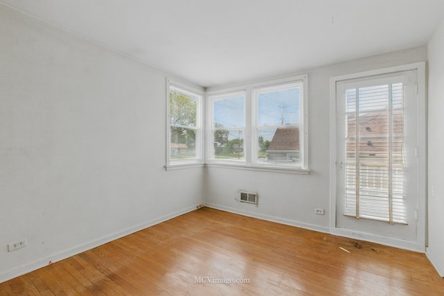 unfurnished room featuring baseboards and light wood-style floors